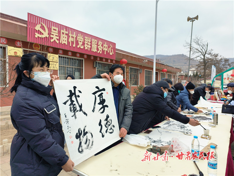 基层文化工作者给群众送书法作品.jpg